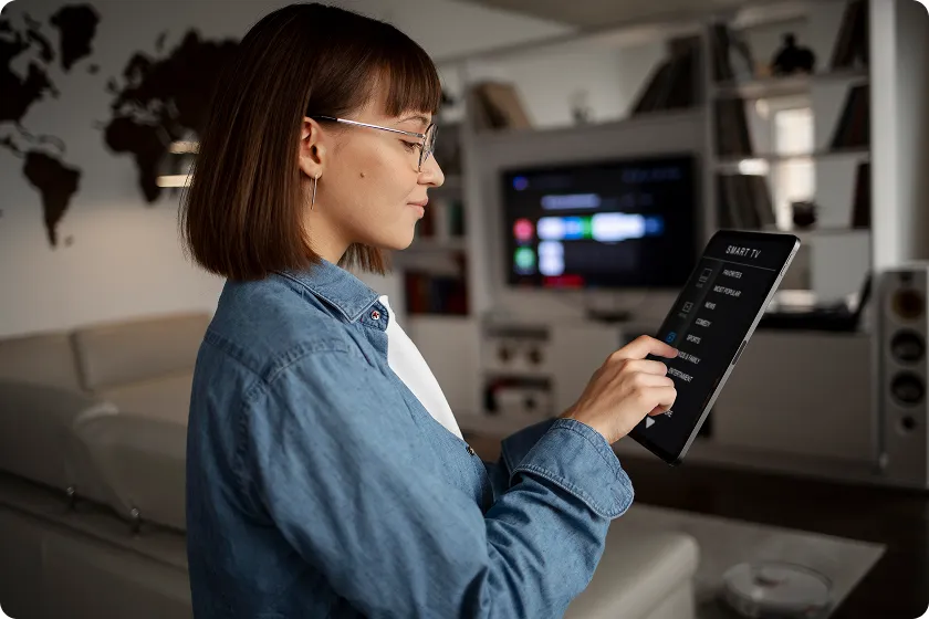 Woman smiling while adjusting air purifier for allergies after home indoor air quality testing.