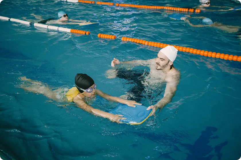 Infant practicing swimming lessons for infants to build strength and balance.