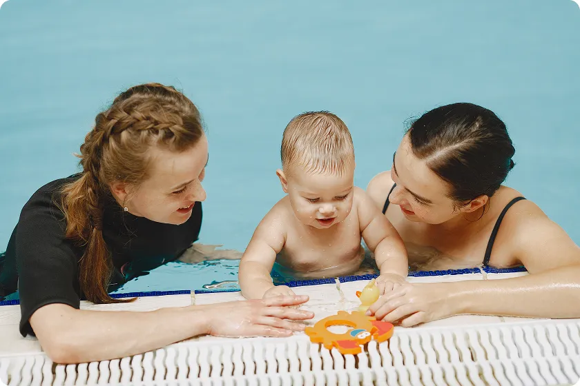 Parent and baby bonding through swimming lessons for infants at YMCA pool.