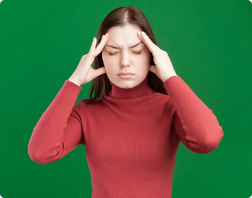 Young woman holds temples, challenging migraine myths and migraine misconceptions.