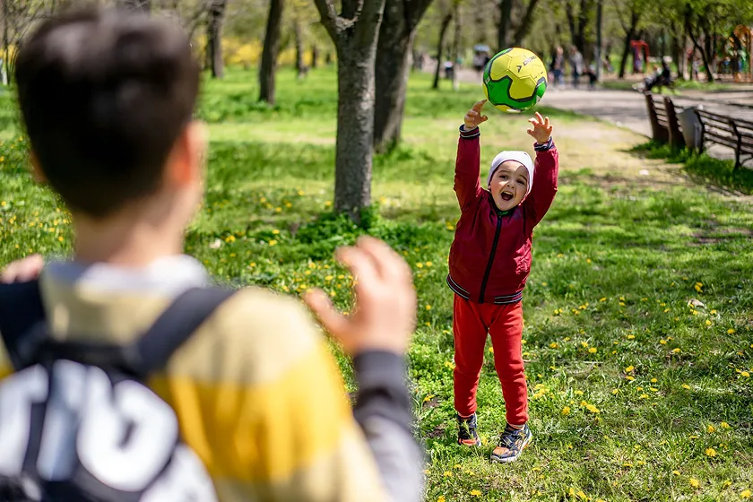 Child catching ball outdoors practicing simple exercise daily fitness routine