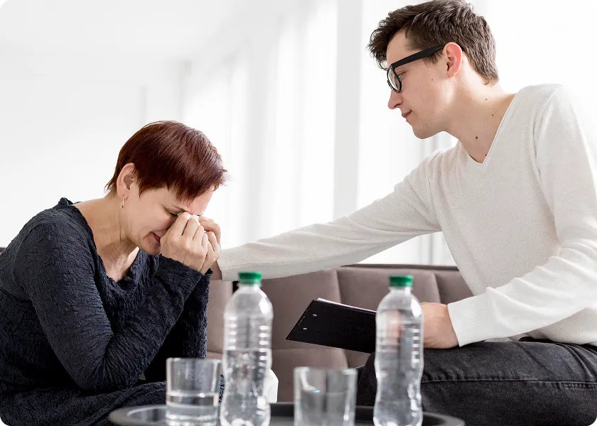 A man comforting a woman who is in distress, but his indifferent look highlights the narcissistic traits, where the man may not fully care about others' emotions.
