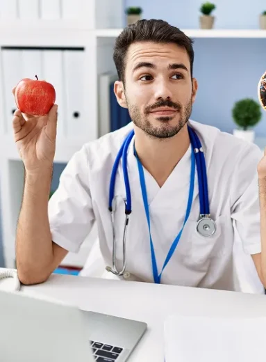 Doctor choosing between apple and donut for healthy eating