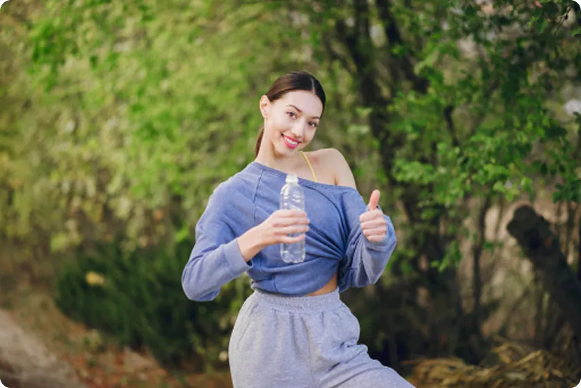 Active woman drinking water outdoors, experiencing magnesium glycinate benefits for women