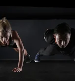 Couple performing push-ups for daily workout routine strength training