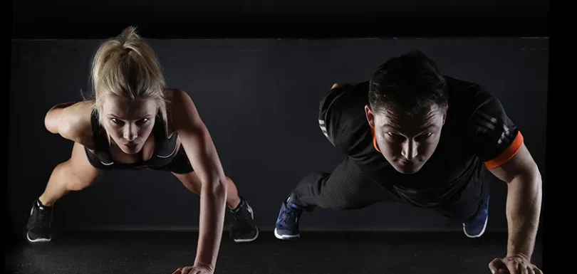 Couple performing push-ups for daily workout routine strength training