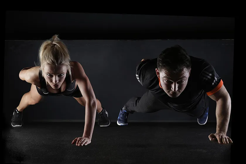 Couple performing push-ups for daily workout routine strength training