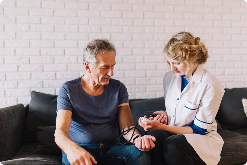 Nurse checking a senior man to help with understanding blood pressure readings.