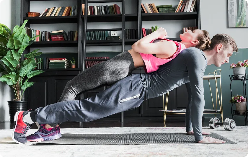 Couple performing partner push ups for arm workouts without equipment