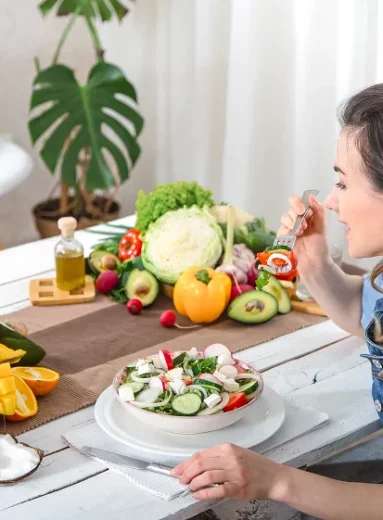 1 Woman eating fresh salad with fruits and vegetables demonstrating gout exercise and healthy diet
