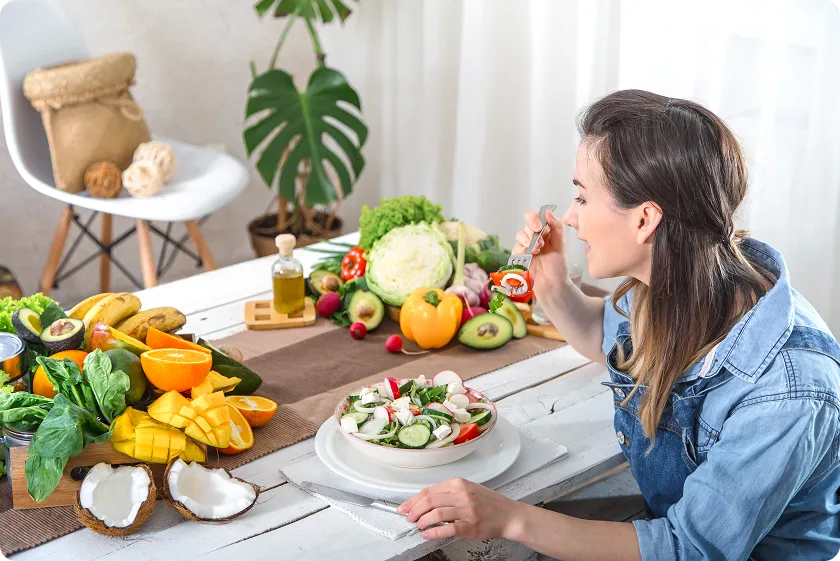 Woman enjoying fresh salad with vegetables supporting gout exercise and diet