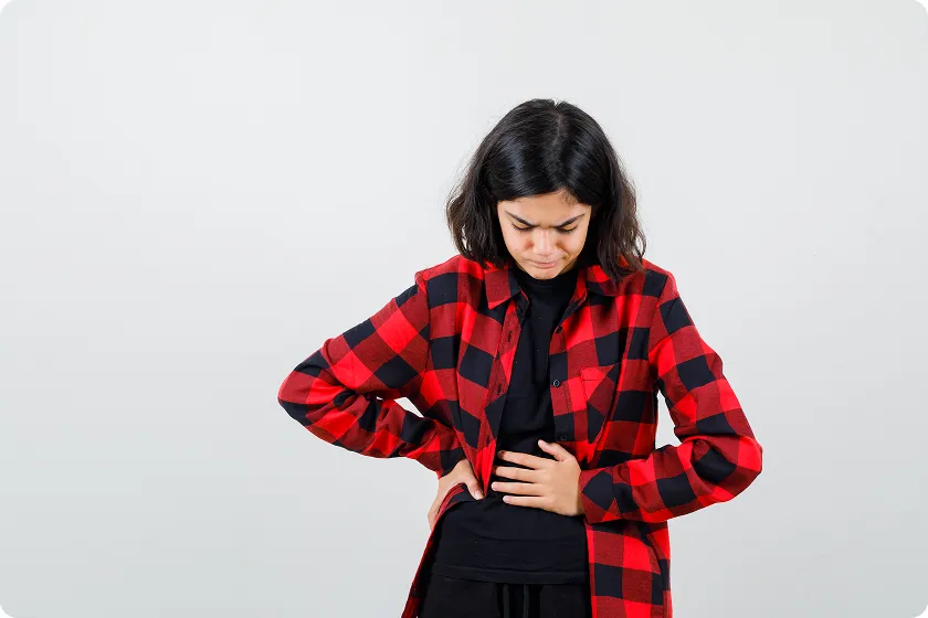 Girl holding her side, showing signs often associated with lupus and kidney disease.