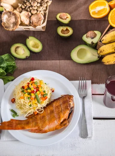 Table spread featuring cooked fish and pasta as foods good for diverticulitis.