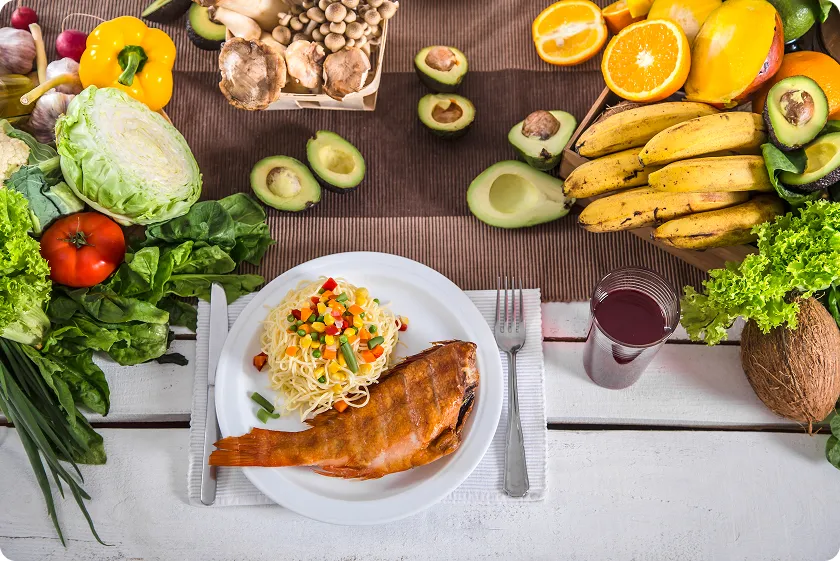 Table spread featuring cooked fish and pasta as foods good for diverticulitis.