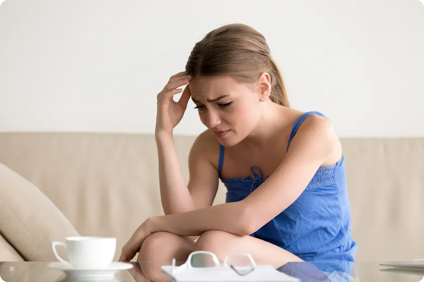 Fatigued woman at a table dealing with the primary symptoms of heart failure in women.