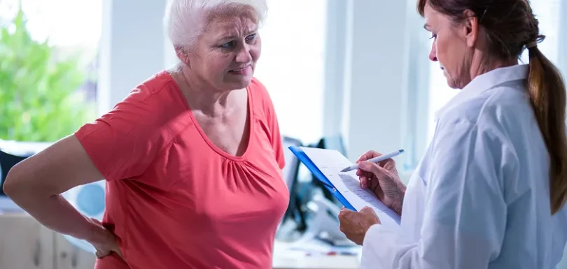 Older woman discussing menopause hip pain with her doctor during a clinical consultation.