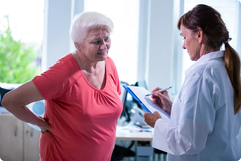 Older woman discussing menopause hip pain with her doctor during a clinical consultation.