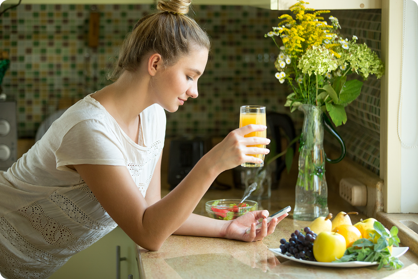 Woman reviewing what foods help with constipation while eating fresh fruit.