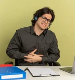 Remote worker grimacing from nausea and gerd beside laptop