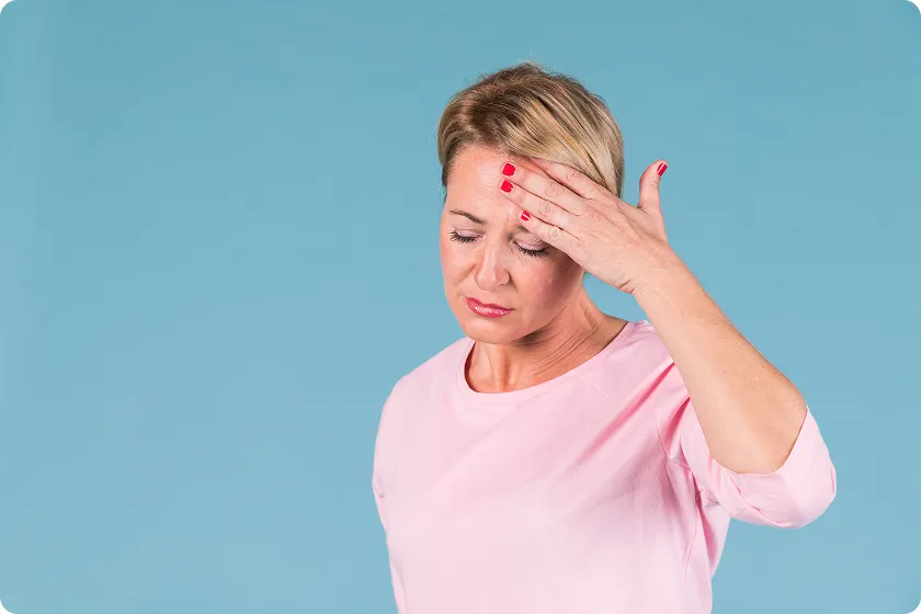 Woman touching forehead showing early signs of stroke in women