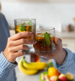 Couple sharing natural remedies for constipation with glasses of herbal mint tea.