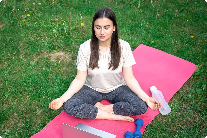 Healthy woman doing outdoor yoga to manage chf symptoms in women through lifestyle changes.