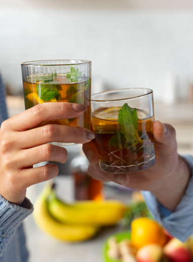 Couple sharing natural remedies for constipation with glasses of herbal mint tea.