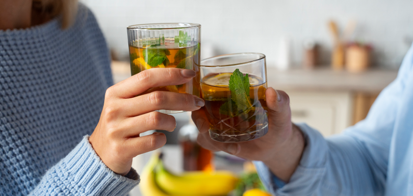 Couple sharing natural remedies for constipation with glasses of herbal mint tea.