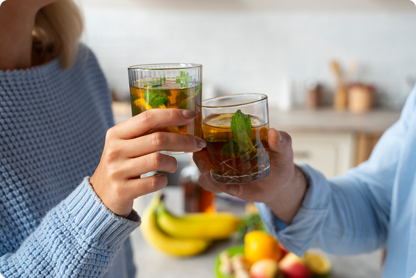 Couple sharing natural remedies for constipation with glasses of herbal mint tea.