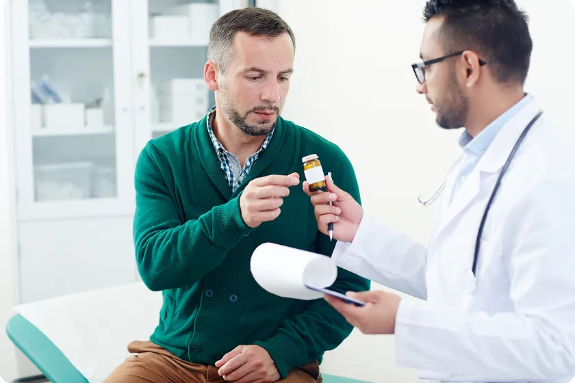 Doctor handing patient a prescription while discussing moderate intensity statin treatment plan.