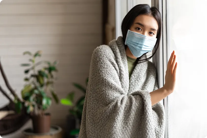 Sick woman isolates at window during incubation of norovirus illness