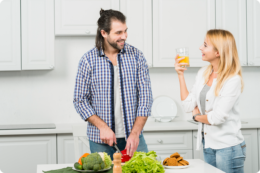 Happy couple preparing a fiber rich diet for constipation with fresh broccoli.