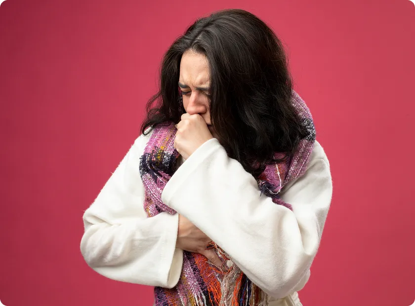 Sick woman wrapped in a scarf coughing from severe symptoms of worsening heart failure.