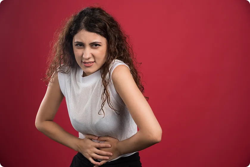A woman holding her stomach in pain showing symptoms of worsening heart failure.