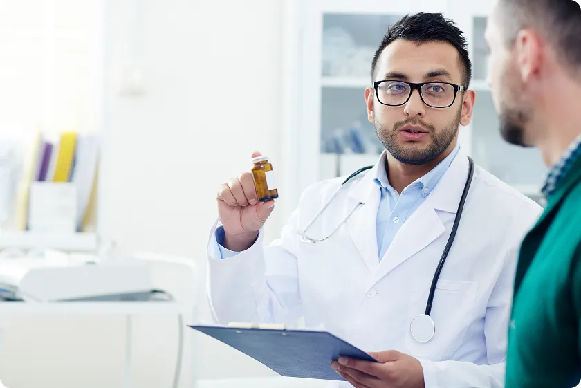 Doctor consulting patient while explaining statin intensity chart and moderate intensity statin options.