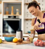 1 Athletic woman pouring a nutritious smoothie as pre workout food for weight loss.