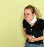 A woman clutching her abdomen, showing Crohn's disease pain location concerns