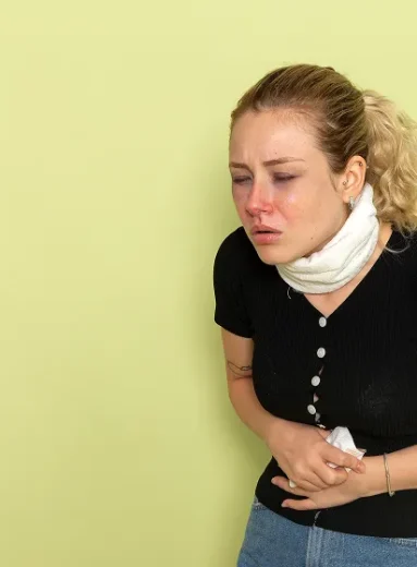 A woman clutching her abdomen, showing Crohn's disease pain location concerns