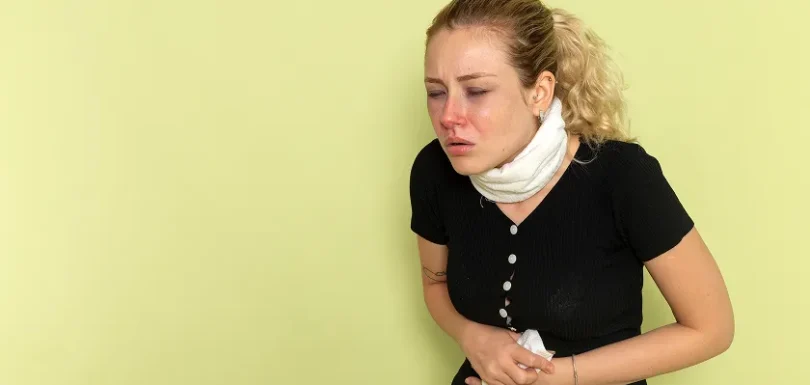 A woman clutching her abdomen, showing Crohn's disease pain location concerns