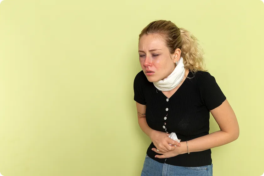A woman clutching her abdomen, showing Crohn's disease pain location concerns