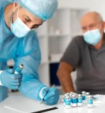 1 Clinician reviews quadrivalent flu vaccine paperwork before senior appointment