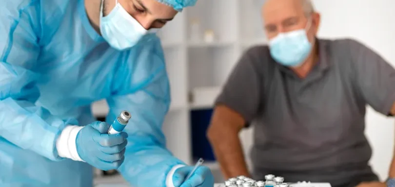 Clinician reviews quadrivalent flu vaccine paperwork before senior appointment