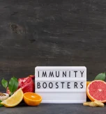 Citrus fruits and ginger around an immunity boosters sign representing acquired immunity definition.