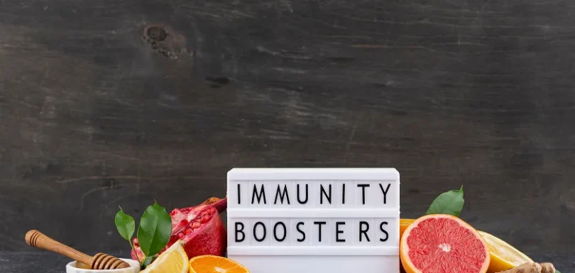 Citrus fruits and ginger around an immunity boosters sign representing acquired immunity definition.