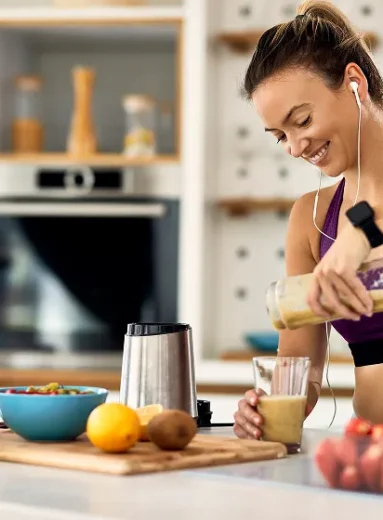 Athletic woman pouring a nutritious smoothie as pre workout food for weight loss.