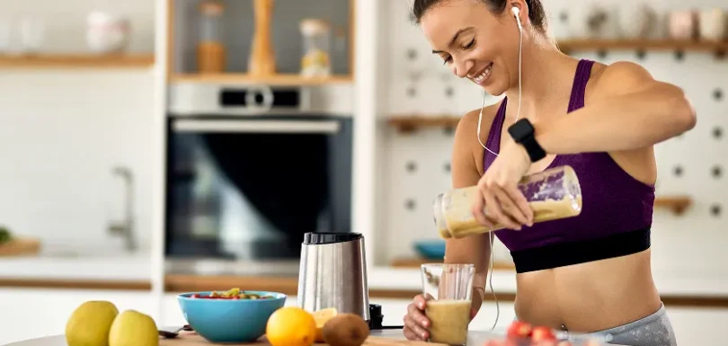 Athletic woman pouring a nutritious smoothie as pre workout food for weight loss.