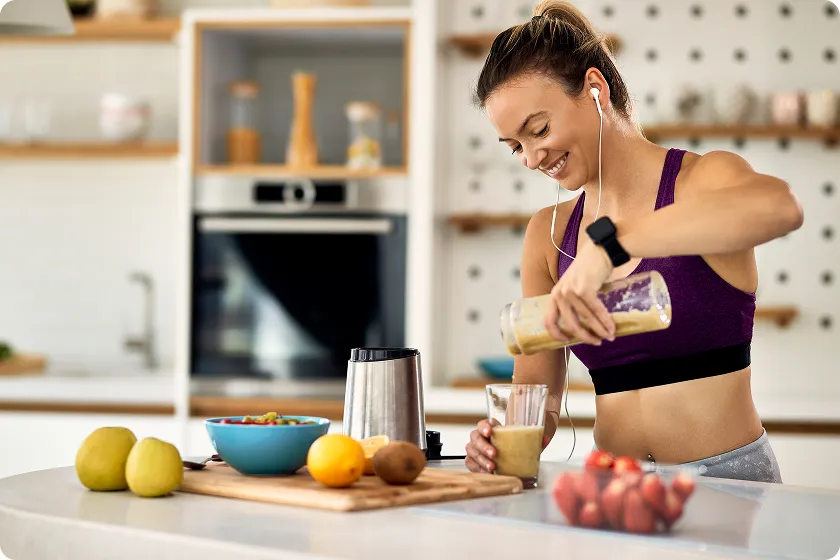 Athletic woman pouring a nutritious smoothie as pre workout food for weight loss.