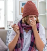 2 Individual sneezing with tissue due to winter allergies night discomfort.