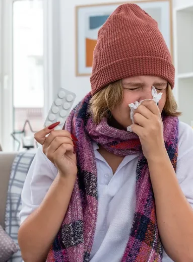 2 Individual sneezing with tissue due to winter allergies night discomfort.
