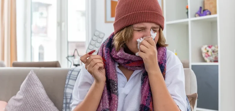 Individual sneezing with tissue due to winter allergies night discomfort.